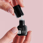 Orbe Ultimate 0 eyelash adhesive lash artist holding the bottle